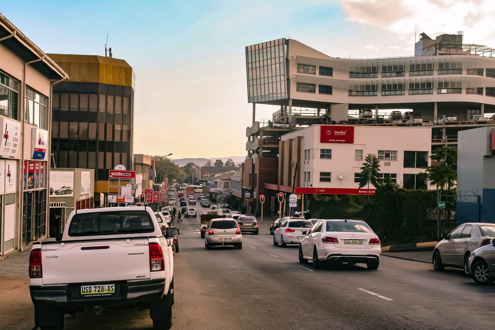 Busy street in Kenya with hire vehicles and pickups in traffic at dusk