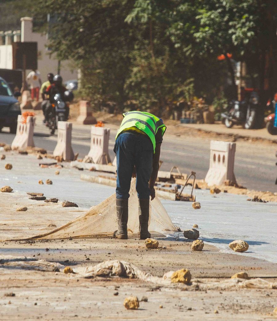 Worker laying out materials on a road project